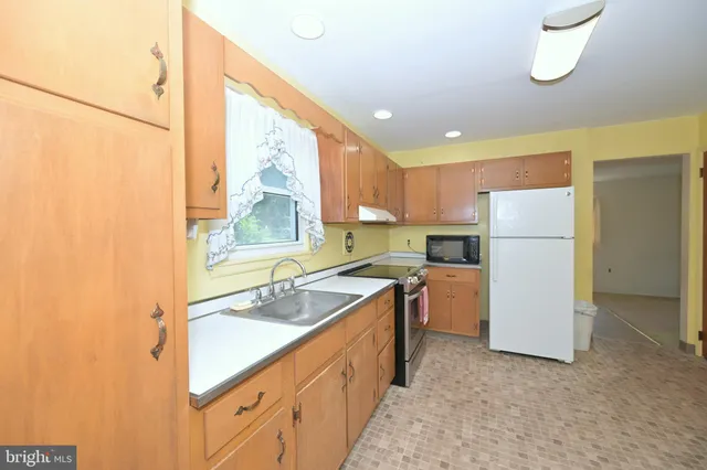 a kitchen with a sink refrigerator and cabinets