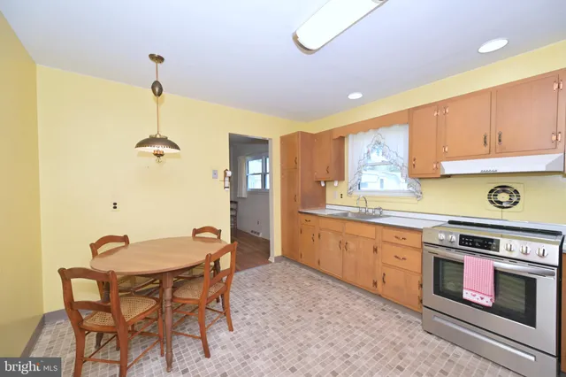 a kitchen with stainless steel appliances granite countertop a stove a sink dishwasher and cabinets with wooden floor