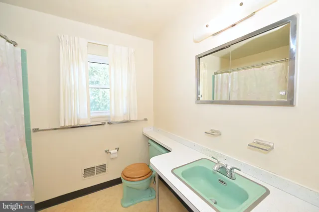 a bathroom with a sink toilet and mirror