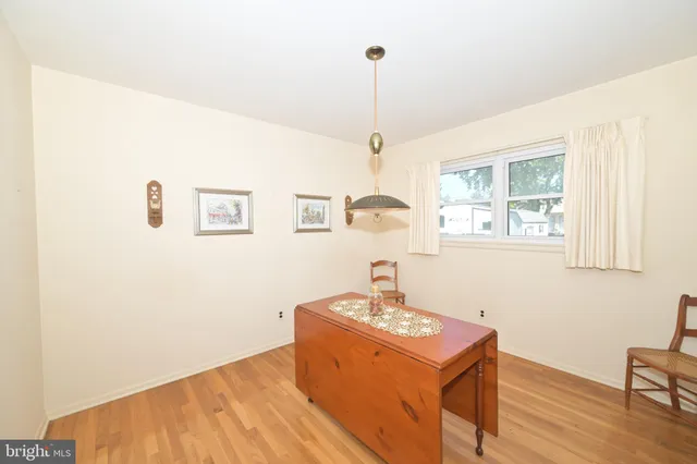 a room with chandelier fan and wooden floor