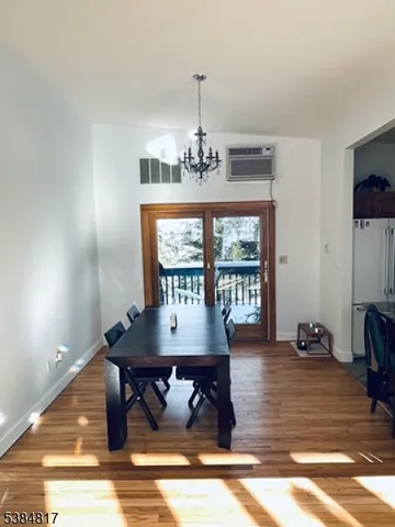 a view of a dining room with furniture a chandelier and wooden floor