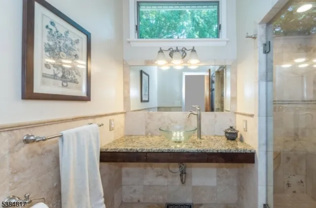 a bathroom with a granite countertop sink and a large mirror
