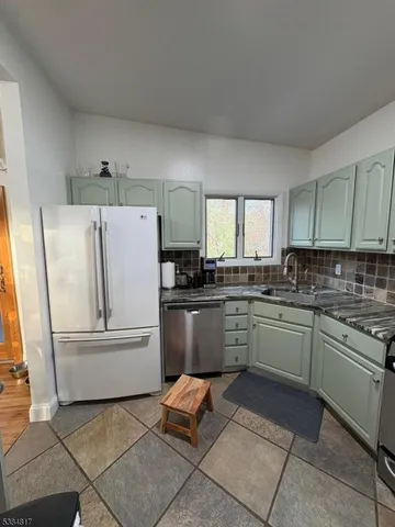 a kitchen with a refrigerator and white cabinets
