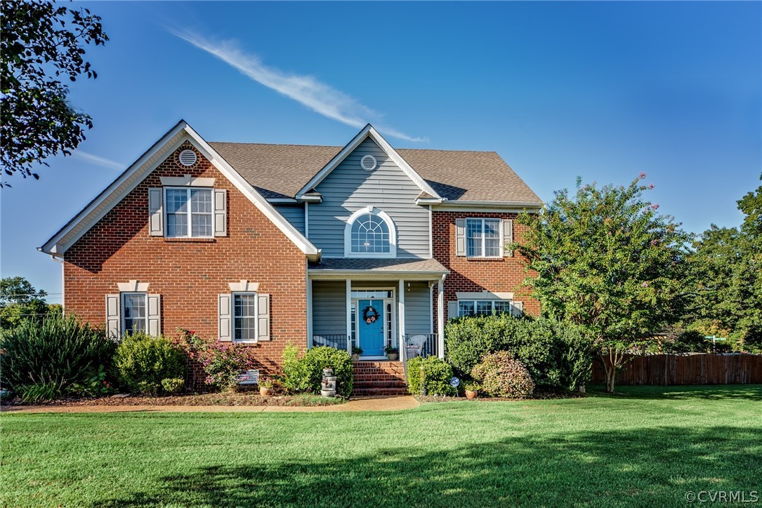 a front view of a house with a yard and trees