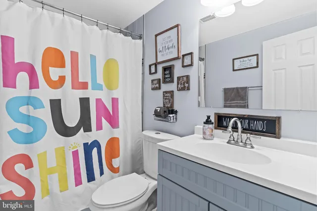 a bathroom with a sink vanity mirror and toilet