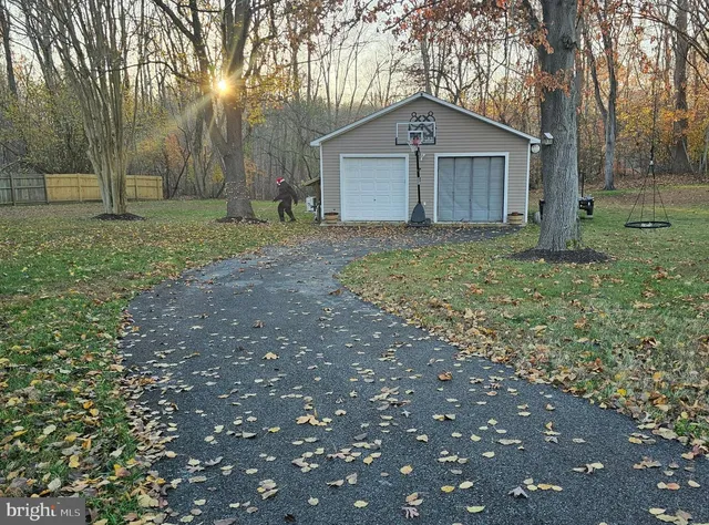 a view of a house with a yard and large tree