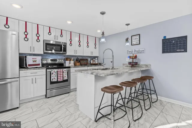 a kitchen with stainless steel appliances a refrigerator sink and white cabinets
