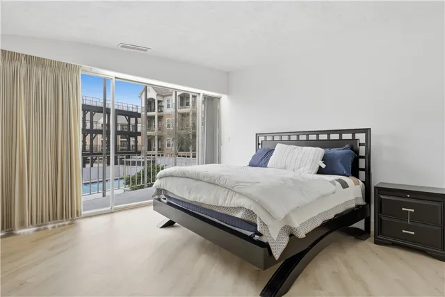 a bed sitting in a bedroom next to a window and dresser