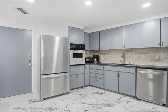 a kitchen with stainless steel appliances granite countertop a refrigerator sink and cabinets