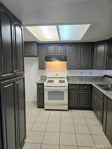 a kitchen with a stove top oven and cabinets