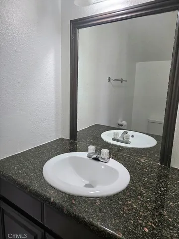 a bathroom with a granite countertop sink and a mirror