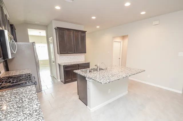 a large kitchen with stainless steel appliances granite countertop a sink and a stove