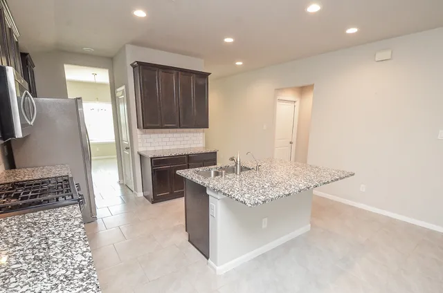 a spacious bathroom with a granite countertop sink a mirror and a bathtub