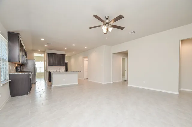 an empty room with closet and a ceiling fan