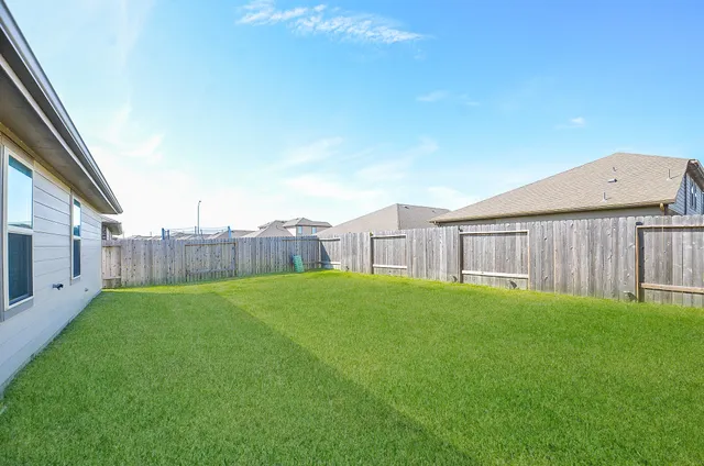 a view of a backyard with wooden fence