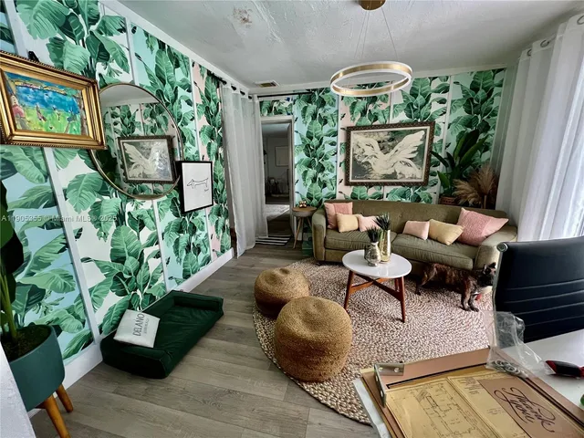 a living room with patio furniture and a potted plant