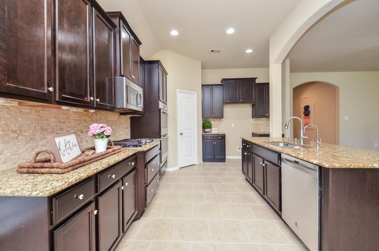 4327 Estes Ridge Lane Katy, TX 77493 - Photo 13 of 37 a kitchen with granite countertop stainless steel appliances a sink stove top oven and cabinets