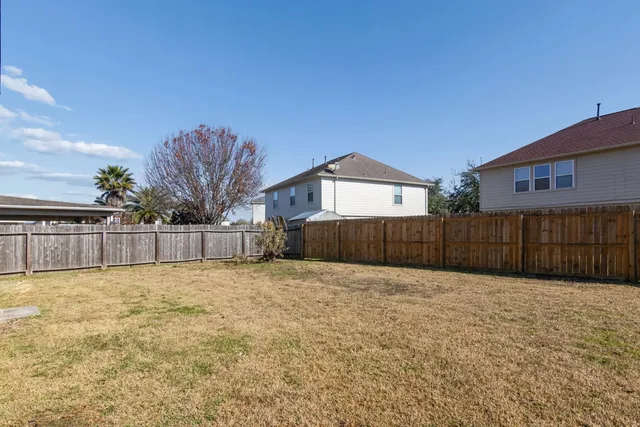 a view of backyard with wooden fence