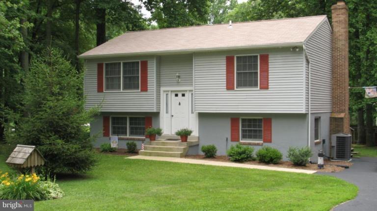 a front view of a house with a garden and plants