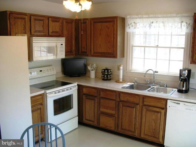 3615 Pine Tree Road Port Republic, MD 20676 - Photo 5 of 16 a kitchen with stainless steel appliances granite countertop a stove a sink and a microwave