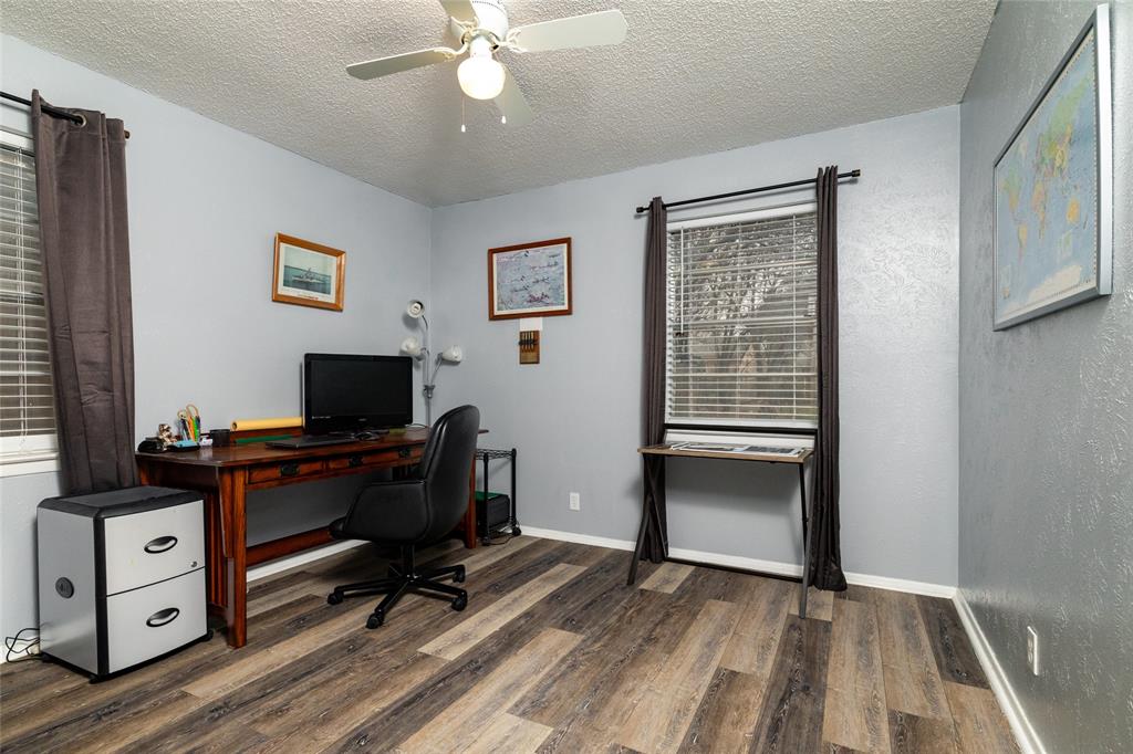 6020 Harrison Way Watauga, TX 76148 - Photo 25 of 32 Home office featuring a textured ceiling, dark wood-style flooring, and a ceiling fan
