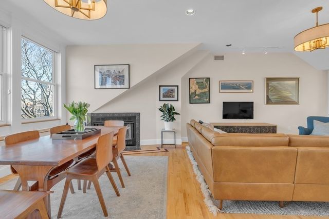 a dining room with furniture a rug and a potted plant