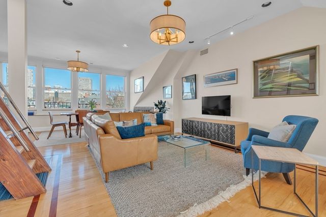 a living room with furniture a rug and a chandelier