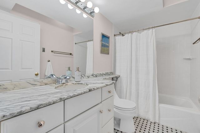 a bathroom with a granite countertop sink a toilet and bathtub
