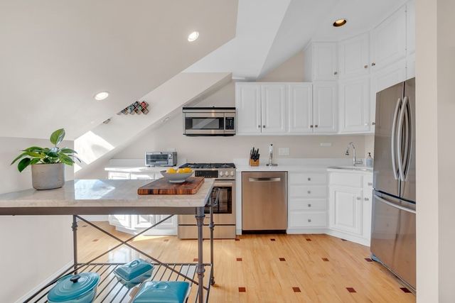a kitchen with a refrigerator and a stove top oven