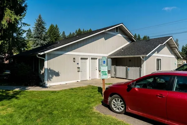 a front view of a house with a garden and parking space
