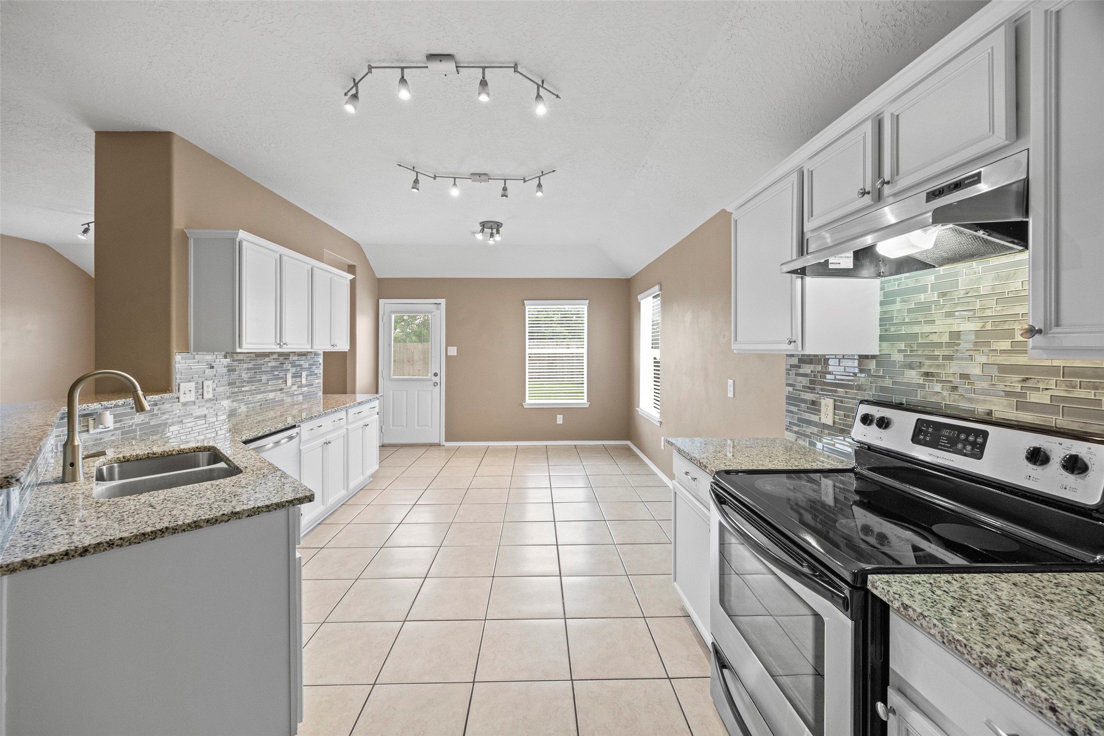 9510 Barr Spring Drive Humble, TX 77396 - Photo 11 of 27 a kitchen with stainless steel appliances granite countertop a sink stove and cabinets