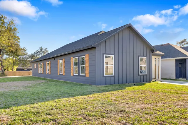 a front view of house with yard and trees around