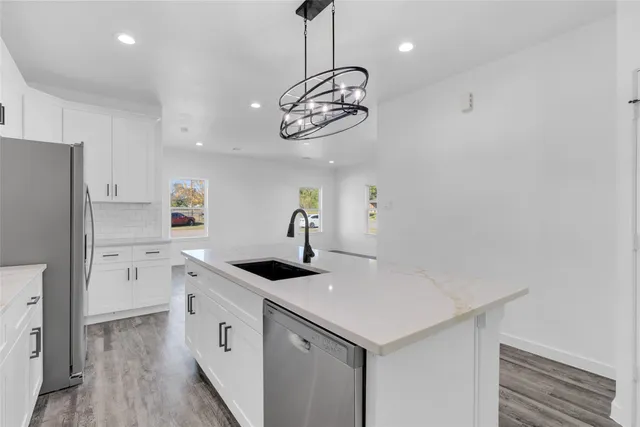 a kitchen with a sink cabinets and wooden floor