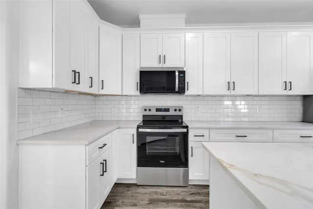 a kitchen with appliances a sink and cabinets