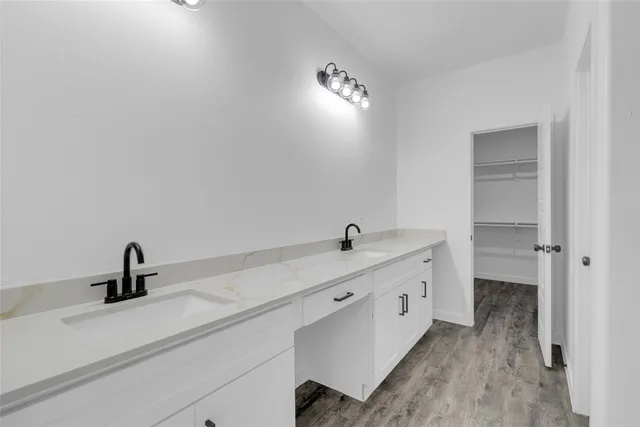 a spacious bathroom with a double vanity sink and mirror