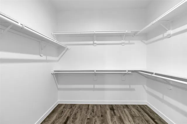 an empty room with a window and wooden floor