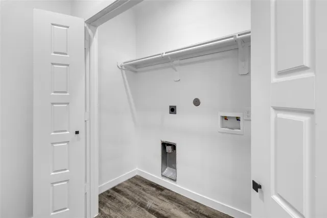 an empty room with wooden floor and window