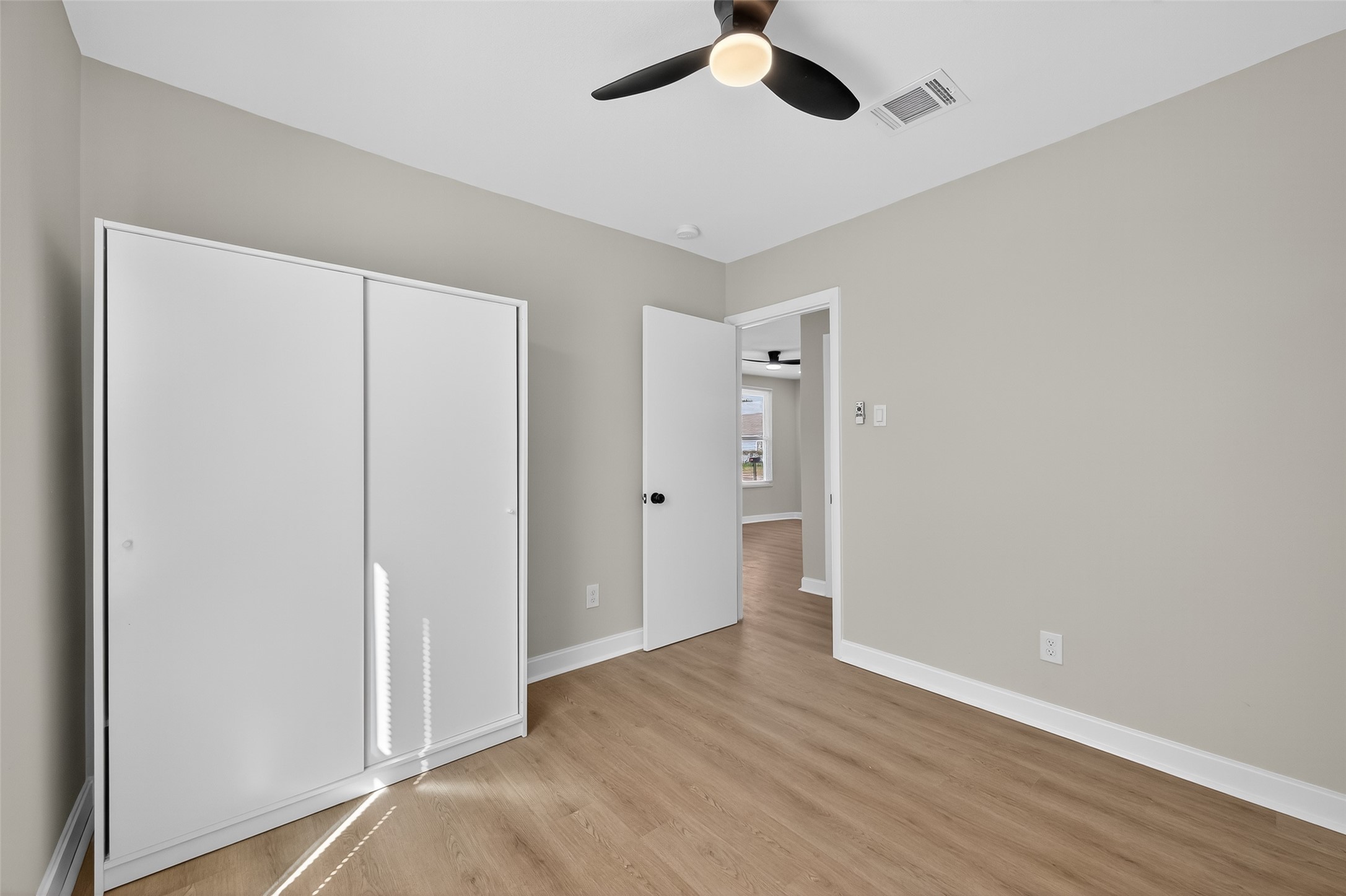 889 Chas Lane Houston, TX 77091 - Photo 20 of 32 an empty room with wooden floor closet and windows