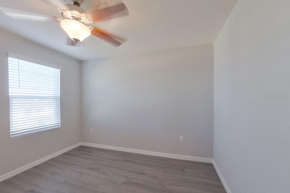 4397 Southwest 85th Lane Ocala, FL 34476 - Photo 10 of 23 an empty room with wooden floor chandelier fan and windows