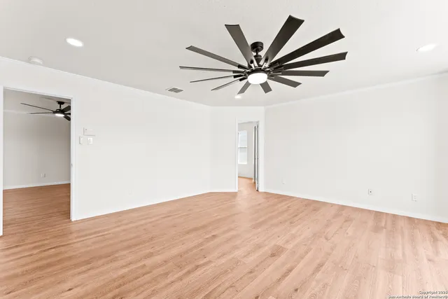 an empty room with wooden floor and windows