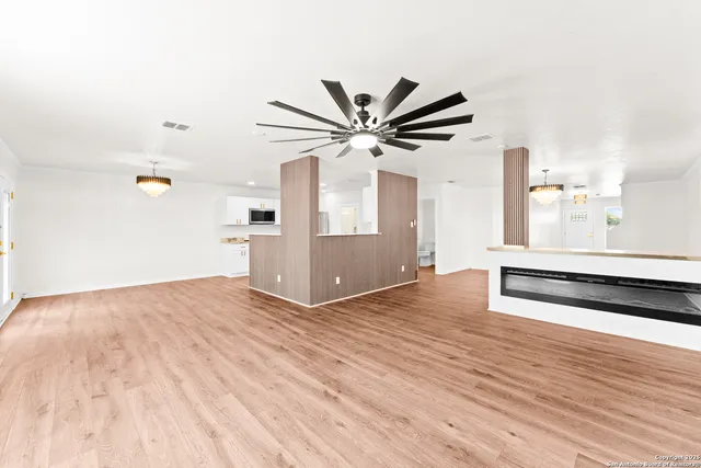 a view of a room with wooden floor and a ceiling fan