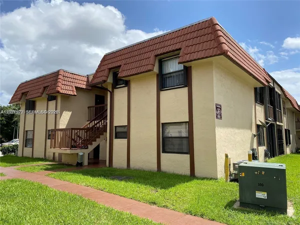 a backyard of a house with barbeque oven and a yard