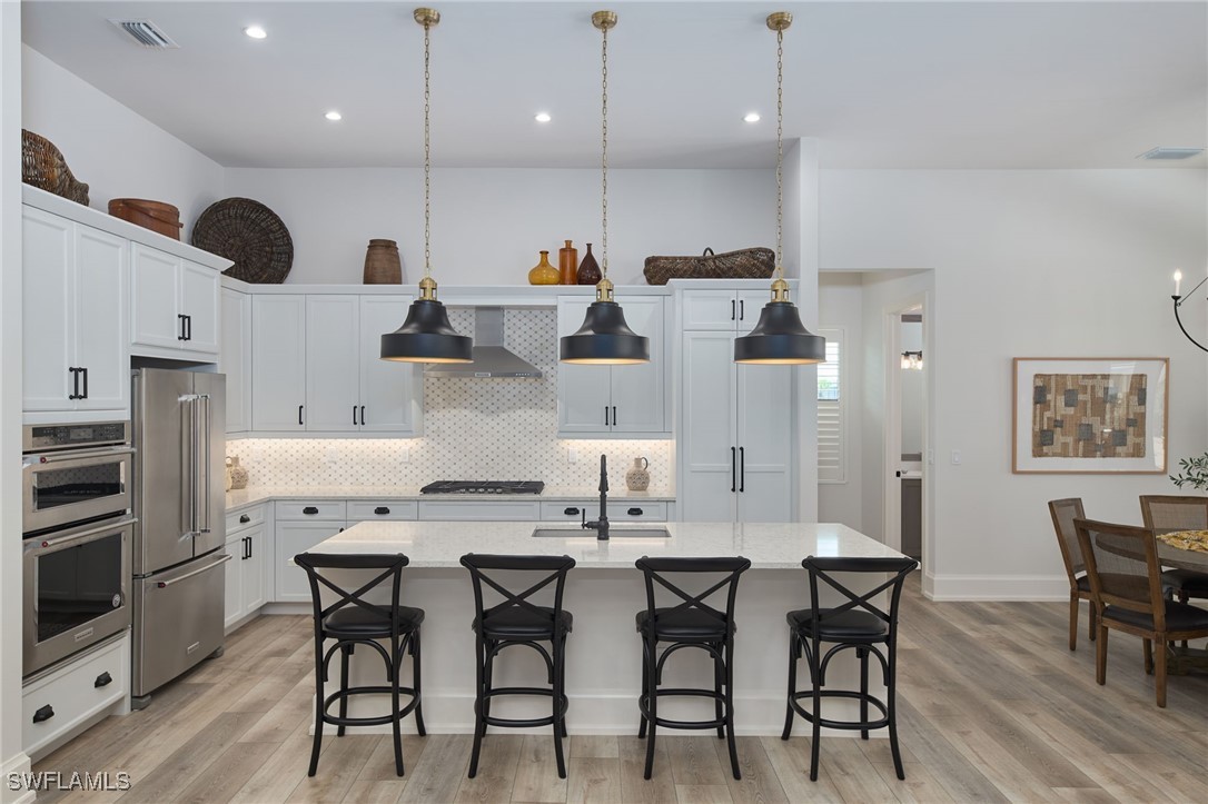 43466 Waterside Trail Punta Gorda, FL 33982 - Photo 7 of 32 a kitchen with stainless steel appliances kitchen island granite countertop a table chairs sink and microwave