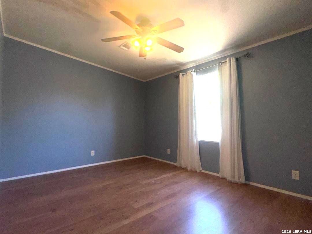 435 N Trail Pleasanton, TX 78064 - Photo 13 of 19 an empty room with wooden floor and windows