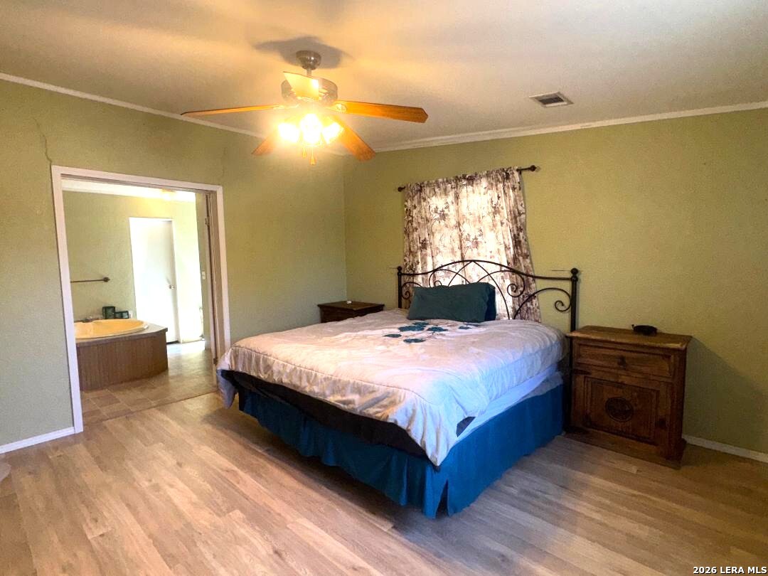 435 N Trail Pleasanton, TX 78064 - Photo 8 of 19 a bedroom with a bed and wooden floor