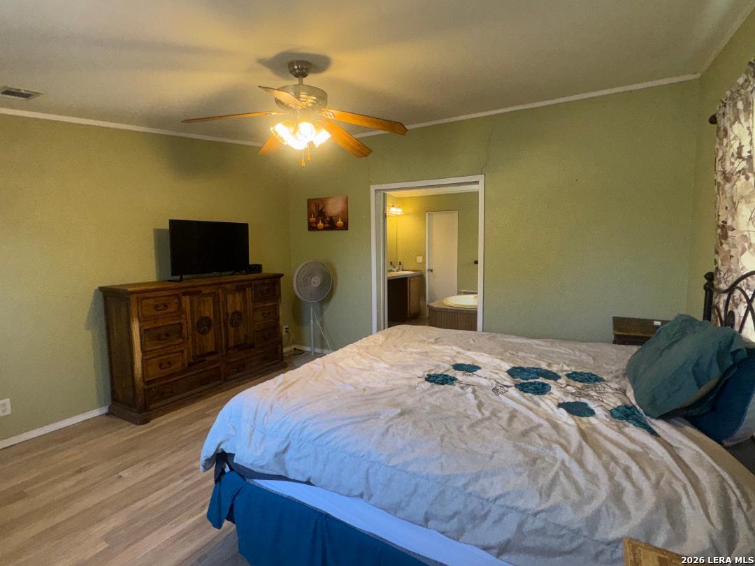 435 N Trail Pleasanton, TX 78064 - Photo 9 of 19 a bedroom with a bed and a flat screen tv