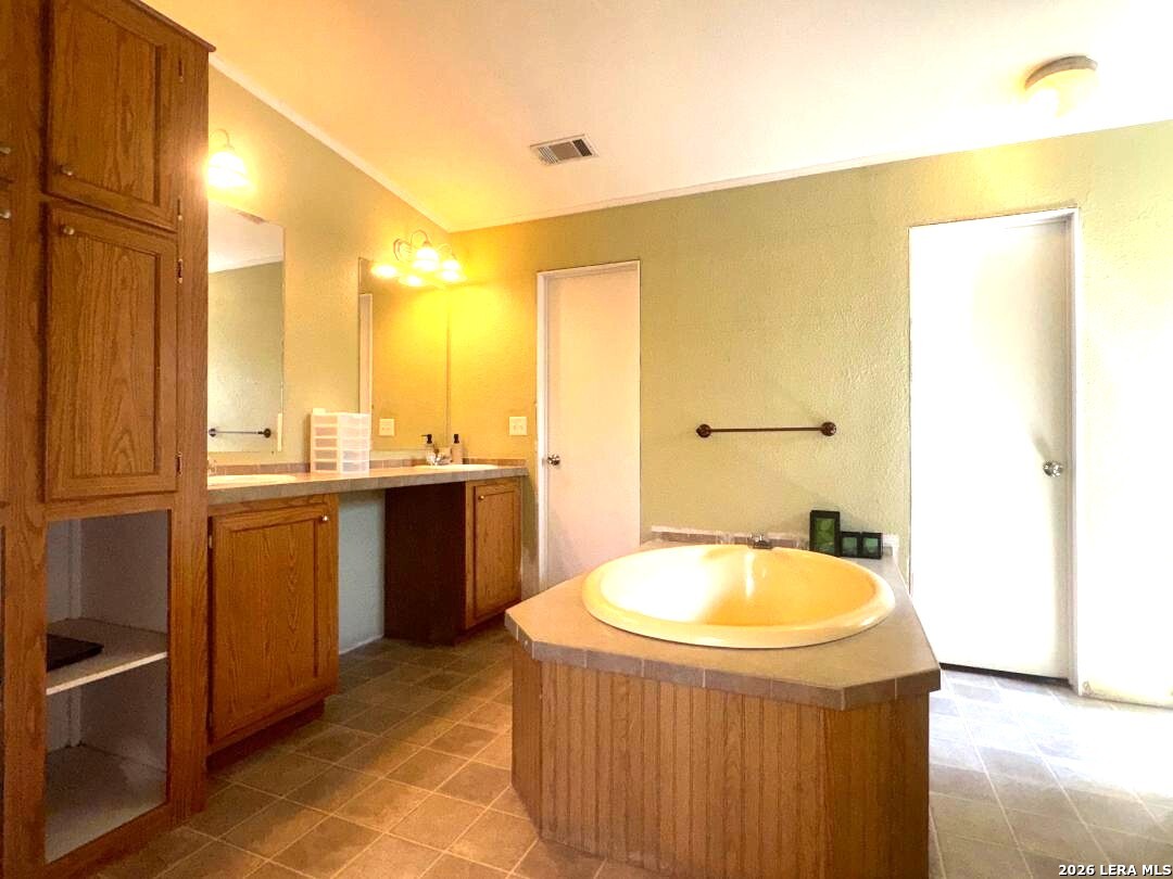 435 N Trail Pleasanton, TX 78064 - Photo 10 of 19 a bathroom with a tub sink and mirror