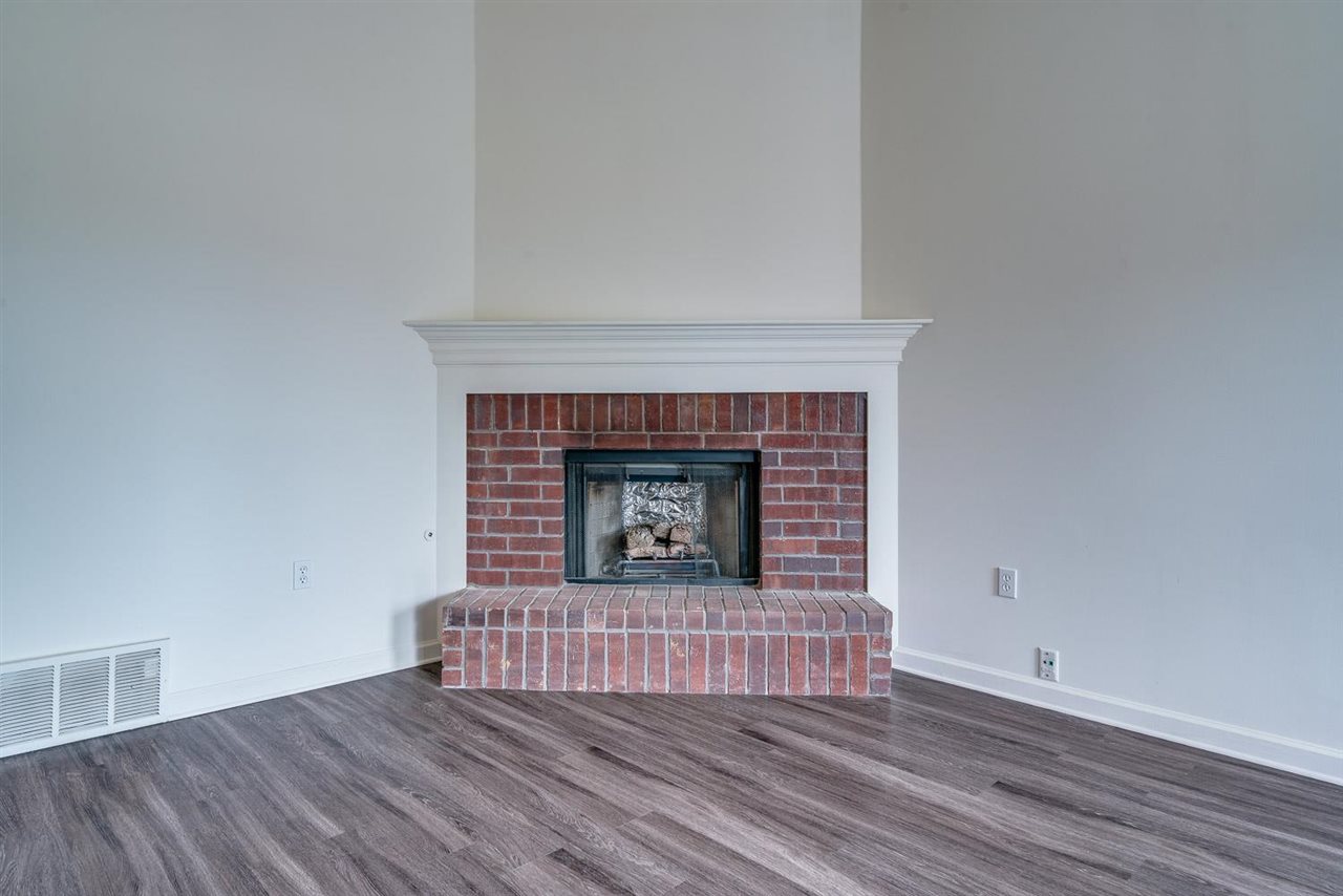 4233 Meadow Ridge Trail Memphis, TN 38141 - Photo 7 of 21 a view of an empty room with wooden floor and a fireplace