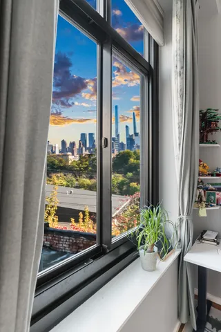 a spacious bedroom with a bed and wooden floor