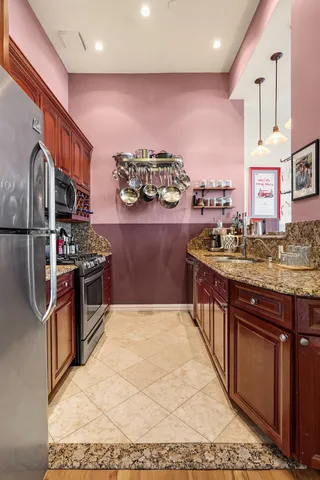 a kitchen with stainless steel appliances granite countertop a refrigerator sink and stove